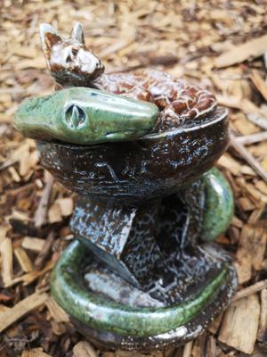 Cat and snake on headrest sculpture